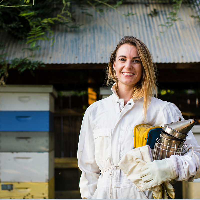 https://www.honeysource.com/wp-content/uploads/2021/05/female-beekeeper.jpg
