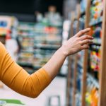 Woman walking through grocery aisle searching for products containing honey